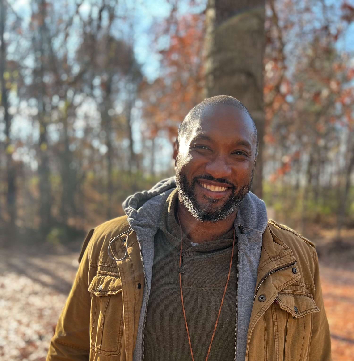 Tony Wong smiles while in a forest.