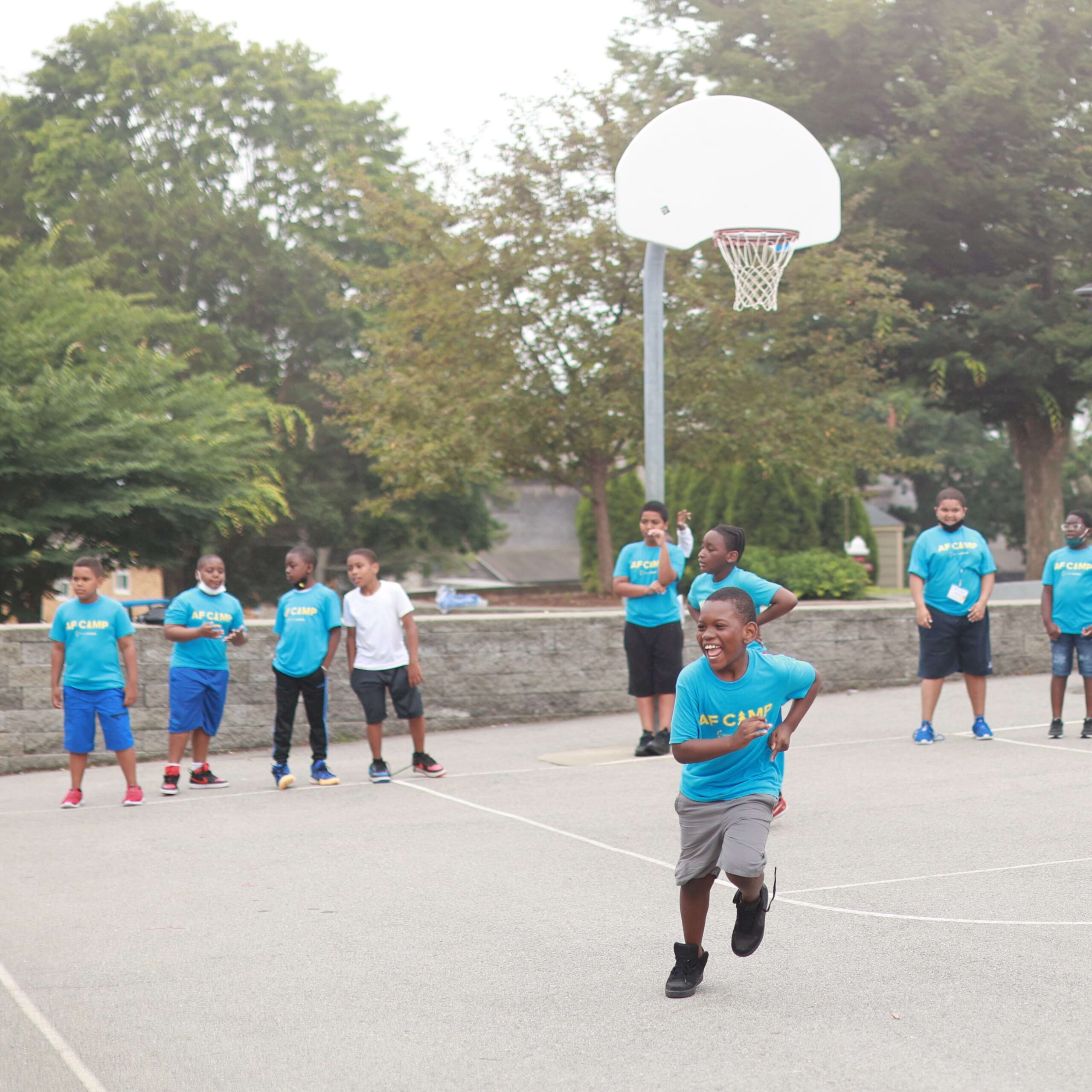 kids playing basketball, running and smiling
