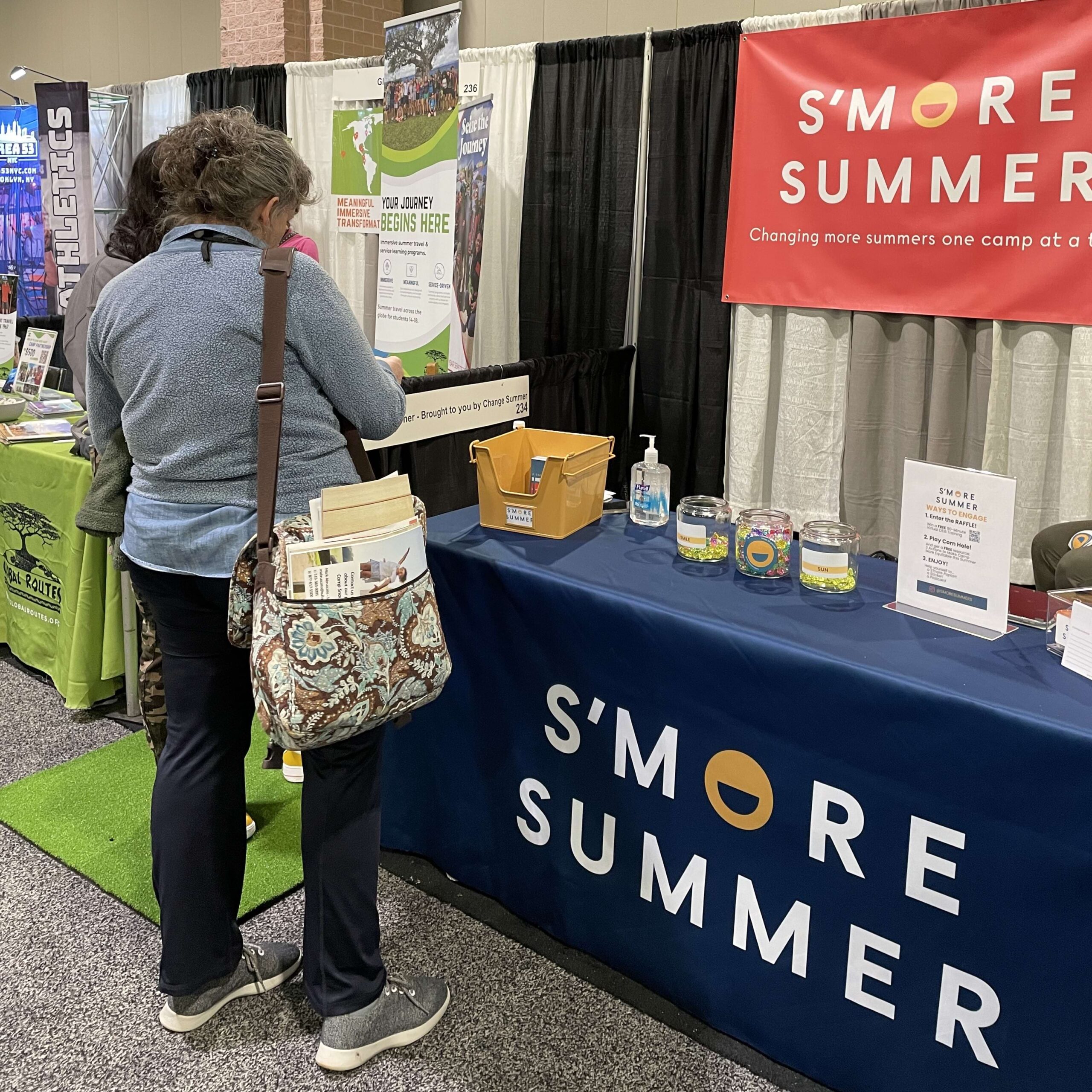 an adult looking at a S'moore Summer booth