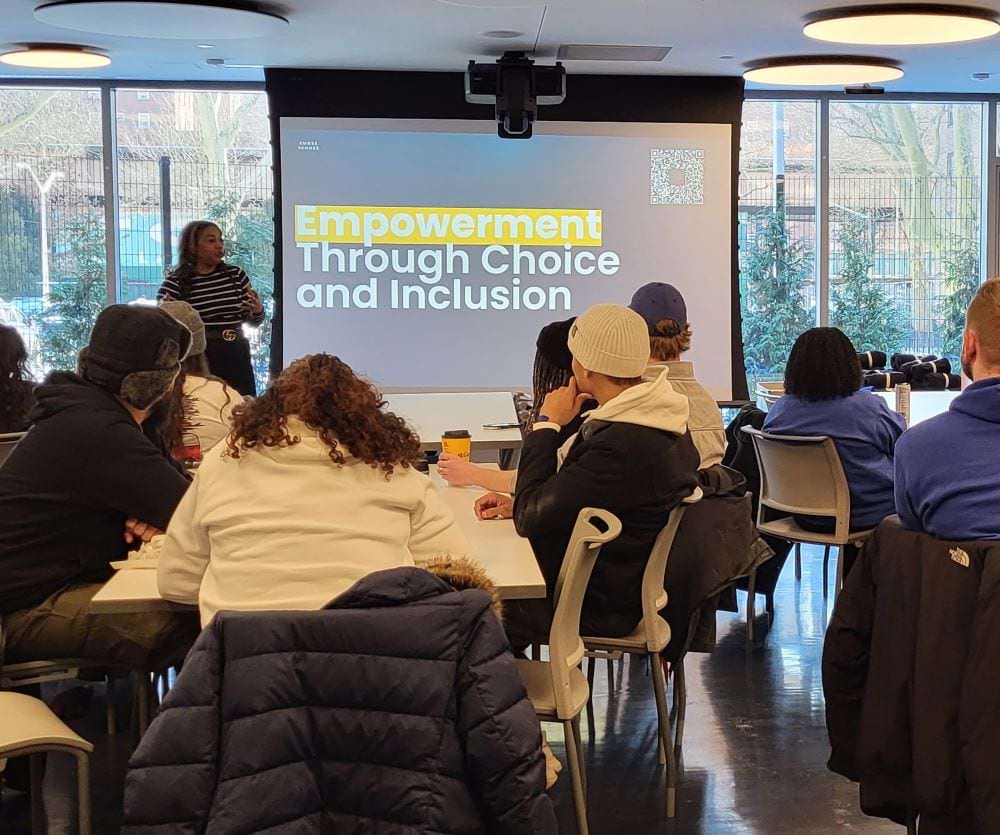 Adults in a room listening to a speaker describe "Empowerment through choice and inclusion."