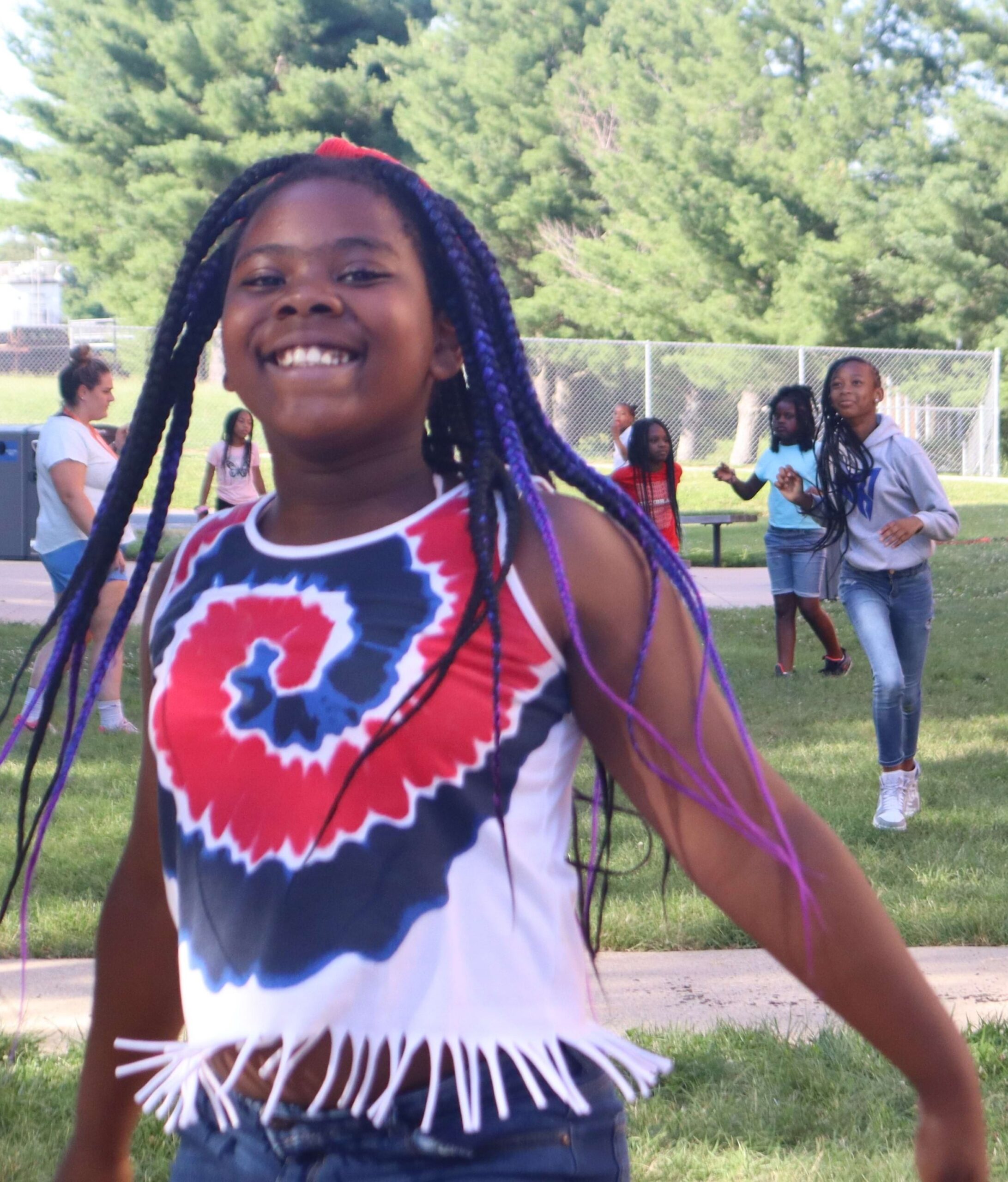 A girl with long hair is running and smiling.